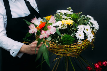 Hands of a woman florist holding a large bouquet of flowers. Close-up. Concept floristics