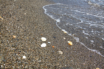 Sea tide. Shore with stone coating. Wave at sea. Background and texture.