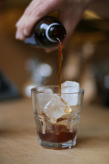 glass of coffee cold brew and ice on wooden table