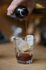 glass of coffee cold brew and ice on wooden table