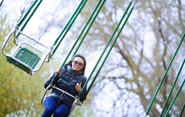 Woman riding on the chain swing at amuzement park