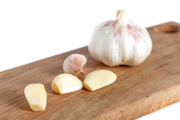 garlic cloves and onion on wooden board isolated on white background