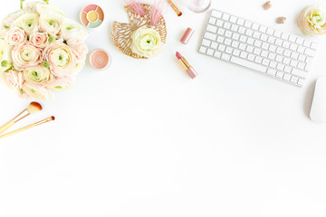 Stylized women's home office desk. Workspace with computer, bouquet ranunculus and roses, clipboard, feminine golden fashion accessories isolated on white background. Flat lay. Top view.