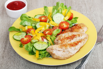 Grilled chicken breast with raw vegetables salad