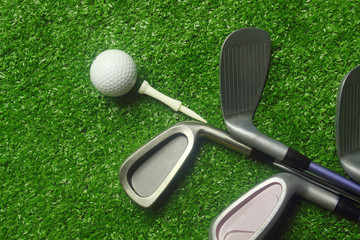 Golf balls and golf clubs on green grass.Golf equipment in the top view.Sports that people around...