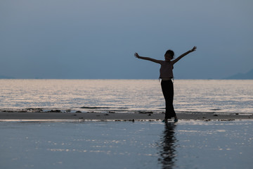 Asian girl enjoying herself during sunset on the beach