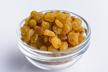 golden raisins on a white acrylic background