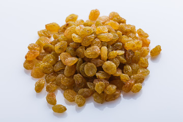 golden raisins on a white acrylic background