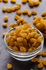 golden raisins on a dark stone background