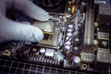 Expert is inserting CPU, processor into the motherboard socket with gloves on 