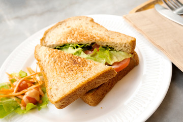 Breakfast, sandwiches, bacon and cheese and vegetables on the marble table