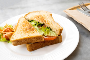 Breakfast, sandwiches, bacon and cheese and vegetables on the marble table
