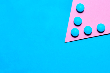 blue tablets on a paper background of blue and pink with copy space