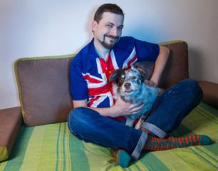 emotional man fan sitting on sofa with dog