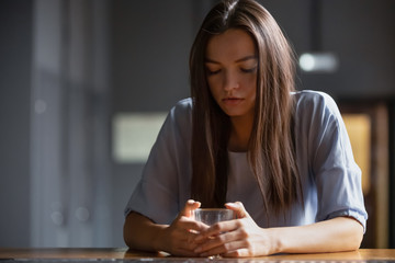 Pensive young woman sitting on bar counter drink alcohol