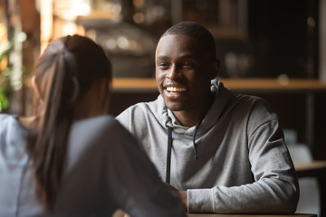 Black cheerful guy chatting with girl during speed dating