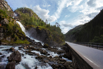 Fototapeta na wymiar Norway landscape, waterfall near a road. beautiful destinations