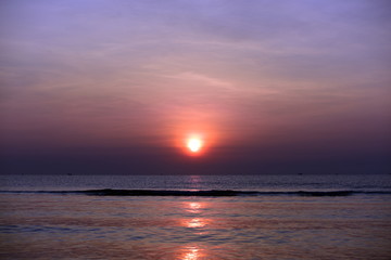 The rising sun view and the beach. Beautiful golden yellow sky and sun