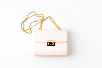 Fashion pale pink handbag on white  background. Flat lay, top view. Spring/summer fashion concept in pastel colored