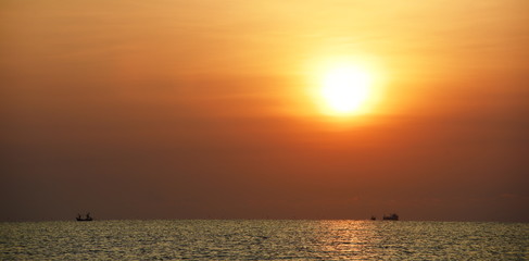 The rising sun view and the beach. Beautiful golden yellow sky and sun