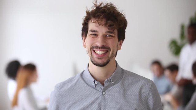 Smiling millennial professional looking at camera posing in office