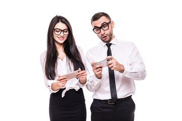Portrait of young emotional business colleagues couple play games by mobile phones isolated over white wall background