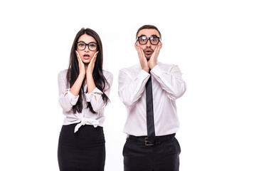 Portrait of young shocked business colleagues couple isolated over white wall background.