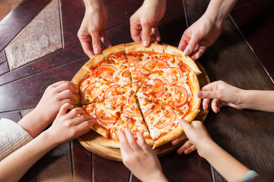 children eat pizza in a restaurant.
