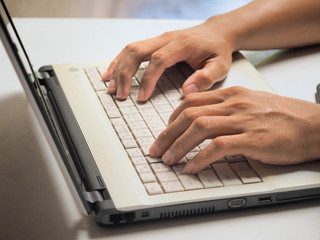 hands typing on laptop keyboard