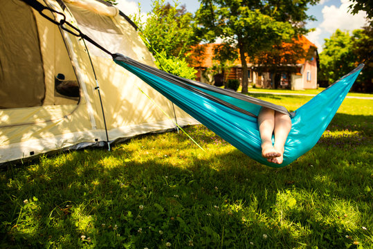 Little girl in the hammock and the tent in background