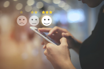 Business woman use mobilepressing smiley face touch screen