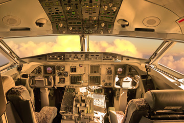 Cockpit of the airplane with sunset sky view through a windshield 