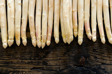fresh organic white asparagus on an old rustic brown wooden table