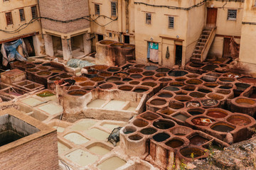 View inside of old medina in Fes, a traditional and old tannery with workers working making methods...