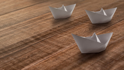 White paper ships on a wooden rustic background moving towards one direction.