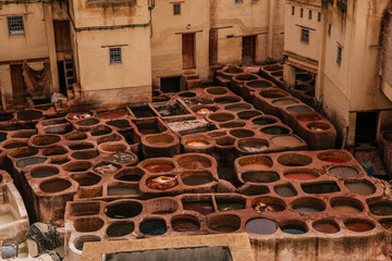 View inside of old medina in Fes, a traditional and old tannery with workers working making methods of leather in the city Fes, Morocco, in april of 2019. 
