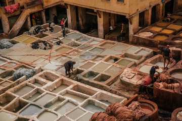 View inside of old medina in Fes, a traditional and old tannery with workers working making methods of leather in the city Fes, Morocco, in april of 2019. 