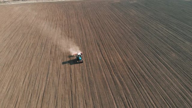 Aerial footage of vintag tractor plowing dry field. Agronomic activities in spring