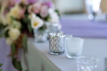 Small candlesticks on a table of a groom and a bride