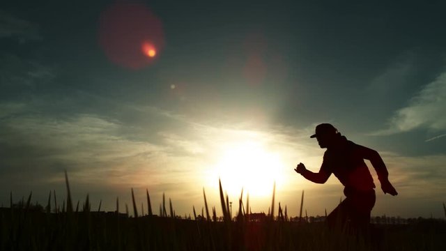 Super slow motion of running man silhouette in sunset. 