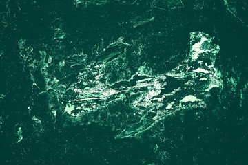 Vintage green background. Rough painted wall of emerald color. Imperfect plane of virid colored. Uneven old decorative toned backdrop of green tint. Texture of emerald hue. Ornamental stony surface.