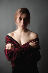 Young woman with bare shoulders on gray background.