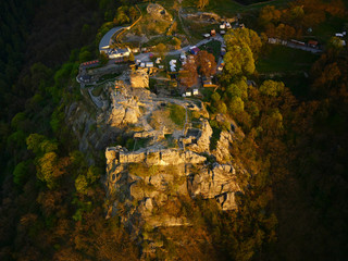 Medieval Regenstein Castle in the Harz mountains, aerial view. Ruined castle near Blankenburg, Saxony-Anhalt, Germany. Beautifully sunlit by the evening sun in springtime during festival season.