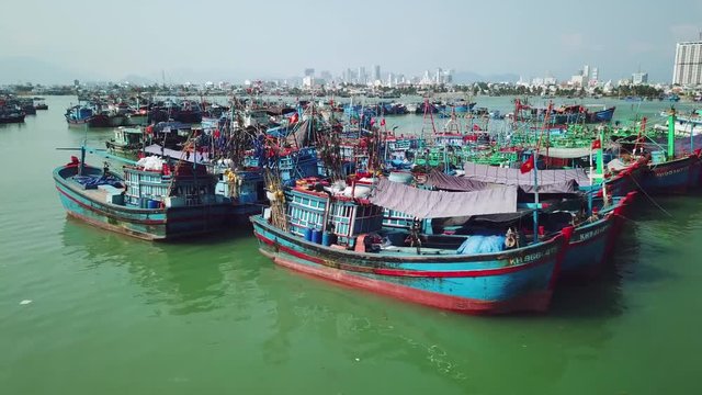 Aerial drift coastal pier parking many ships old wooden fishing boats. Authentic culture style Asia Vietnam. Business profession typical poor. Cityscape background horizon sea blue sky sunny day Drone