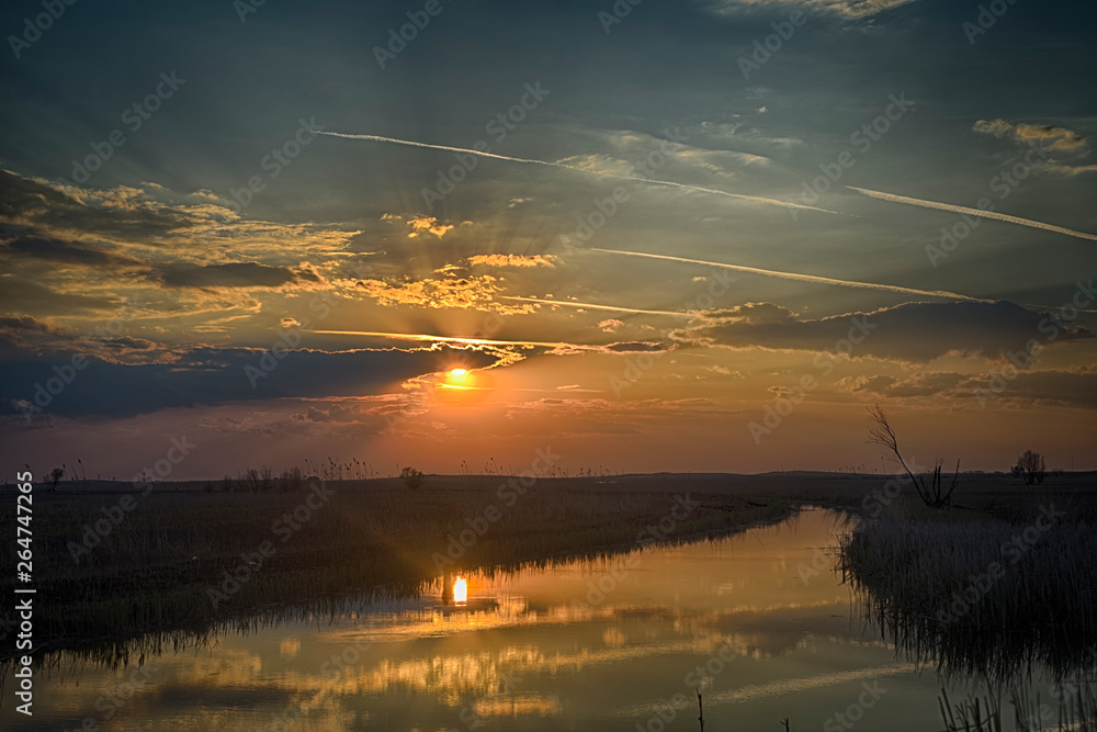 Wall mural sunset on the river in the astrakhan region. irrigation system for agriculture