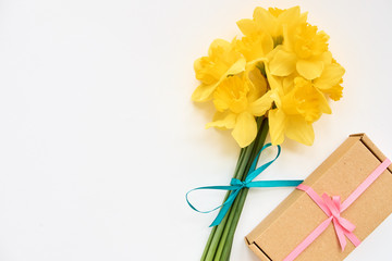 bouquet of daffodils with gift box on a white background