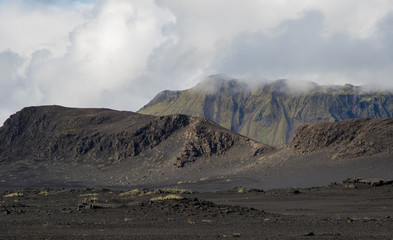 Fototapeta na wymiar Dramatic iceland landscape with black lava hills looks like a moon.