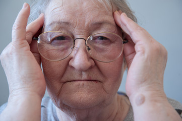Elderly woman with beautiful face in wrinkles with gray hair with glasses. Closeup portrait. Grandmother Retired waiting for social assistance.