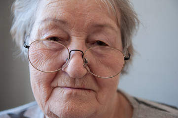 Elderly woman with beautiful face in wrinkles with gray hair with glasses. Closeup portrait. Grandmother Retired waiting for social assistance.