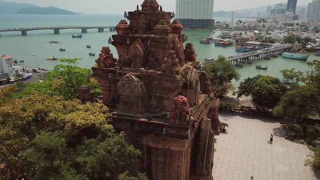Aerial Po Nagar Cham temple around tower Vietnam Nha Trang exotic cityscape. Modern buildings city bridge active road traffic river fishing old boats. Authentic culture style Asia. Sunny day. Sight